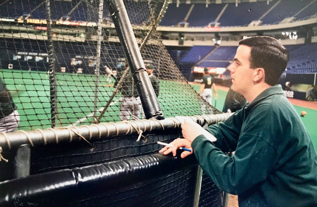 A young John Nemo working as a sportswriter with a notepad at the Metrodome